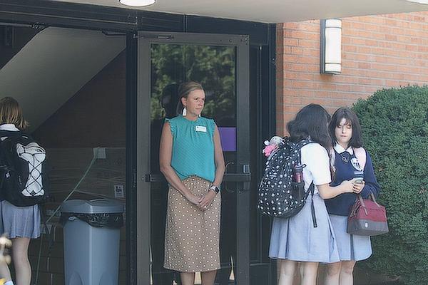 Sara Jones, head of school at Mount St. Mary Academy in Little Rock, stands guard at a doorway at dismissal Aug. 12, the first day of school. Educators have been advised by police to limit entryways and have a staff person at each opening who only lets students into school buildings. (Chris Price photo)