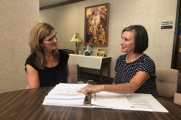 Ileana Dobbins (left), associate superintendent of Catholic schools, and Theresa Hall, superintendent for Catholic Schools, review gun safety response plans submitted by diocesan schools. Hall asked principals to review their gun safety response plans before the start of the 2022-2023 school year. (Chris Price photo)