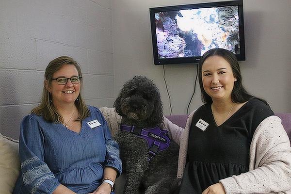 Amy Owens (left), Counseling Director, and Eden Coker, Freshman Counselor and Transition Coordinator, spend time with Oliver, the therapy dog, in the Wellness Room at Mount St. Mary Academy in Little Rock on August 31.