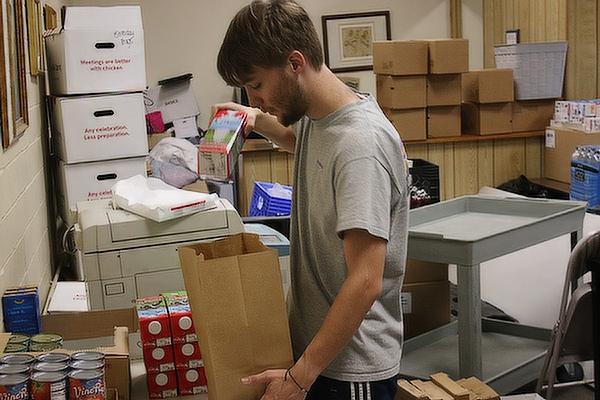 Итан Едвардс пакује намирнице за породице са децом у Хелпинг Ханд оф Греатер Литтле Роцк, остави за храну која пружа помоћ хиљадама породица у централном Арканзасу, септембра.  