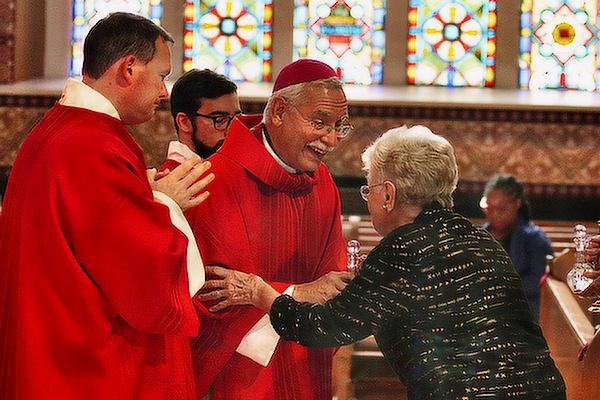 Bishop Anthony B. Taylor accepts the gifts from Pauline Jegley before handing them to Deacon Matt Glover (left), the Diocese of Little Rock’s chancellor for canonical affairs, and Father Joseph de Orbegozo, PHL, rector of the Cathedral of St. Andrew, at the 28th Annual Red Mass into the Cathedral of St. Andrew in Little Rock, Oct. 7. (Chris Price)