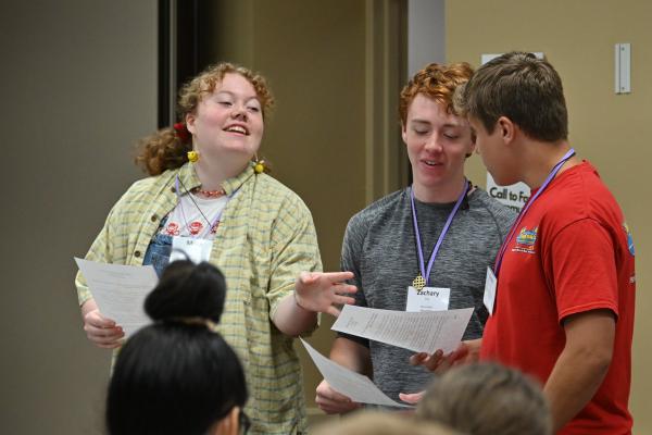 Mora Boyd of St. Boniface Church in Fort Smith (left), Zach Ellis of Our Lady of the Holy Souls in Little Rock and Parker Vail of Immaculate Conception Church in North Little Rock prepare to lead the C2SI participants in prayer on July 11. (Collin Gallimore photo)