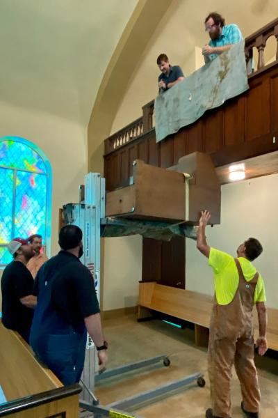 Members of St. John the Baptist Church in Engelberg remove the old organ from the choir loft using heavy machinery. Courtesy Jane Smith. 