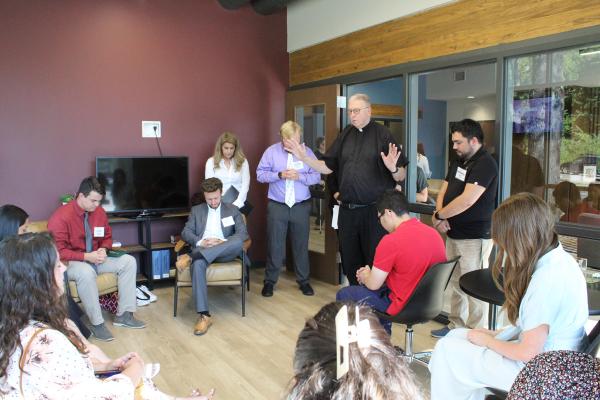 Father John Connell prays over students in the new Catholic campus ministry building before Mass Sept. 6. Students played an important part in the fundraising campaign to construct the building, calling donors and hosting events. Katie Zakrzewski.