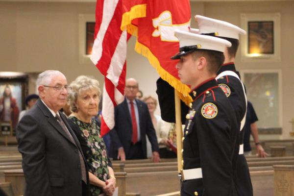 James Badami, a St. Thomas More Society Award recipient, and his wife Bonnie watch the Catholic High School ROTC Color Guard as they hoist flags before the National Anthem during the Red Mass Oct. 6 at Christ the King Church in Little Rock. 