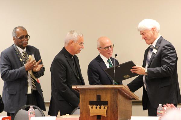 Judge Butch Hale, a parishioner of Immaculate Conception Church in North Little Rock, receives an award from Deacon Jim Goodhart (right), president of the St. Thomas More Society, during the luncheon following the Oct. 6 Red Mass at Christ the King Church in Little Rock. 