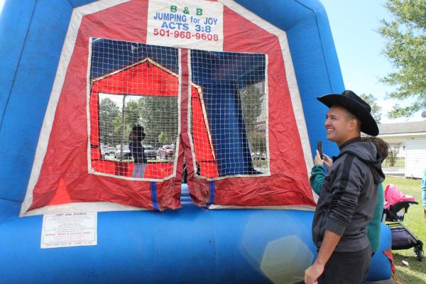 Father Mauricio Carrasco, the pastor of Church of the Assumption, dons a cowboy hat as he stands outside a bouncy house during the heritage festival Oct. 14. Katie Zakrzewski