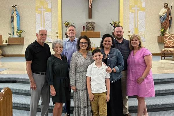 Kate Davis (third from right), the director of finance at Mount St. Mary Academy in Little Rock, stands with family and friends after being received into the Church in June. Her sponsor, Kelly Wewers (far right), also works in financial aid at Mount St. Mary. Courtesy of Kate Davis.