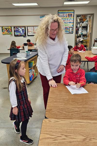 Lucie Cape, the art teacher at St. Joseph Catholic School in Fayetteville, helps students with an art project Nov. 27. Cape and her husband are currently in RCIA. Courtesy of Lucie Cape. 