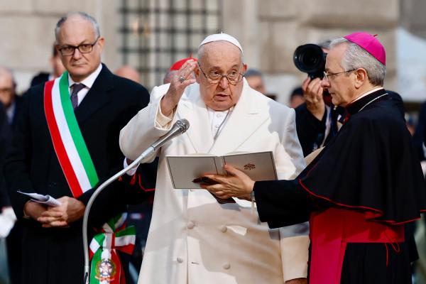 Pope Francis gives his blessing after in front of a Marian statue near the Spanish Steps in Rome Dec. 8, the feast of the Immaculate Conception. Roberto Gualtieri, the mayor of Rome, is at the left.