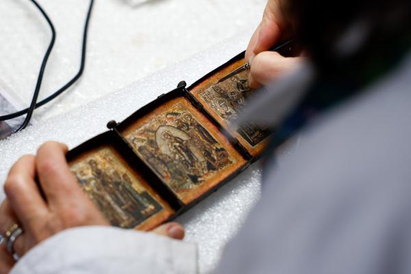 A restorer at the painting and wood materials restoration laboratory of the Vatican Museums works on a painting at the restoration laboratory at the Vatican Dec. 11, 2023. (CNS photo/Lola Gomez)