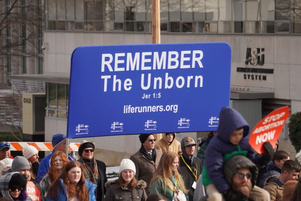 The organization Life Runners hoisted a banner outside the Cathedral during the Mass for Life before carrying the banner to the state capitol.