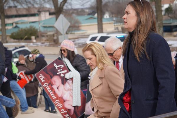 Governor Sarah Huckabee Sanders (right) made her way up the capitol steps alongside a dozen local and state politicians, including Lieutenant Governor Leslie Rutledge (center). 