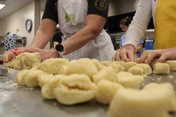 Janie Kelley and Roz Rector cut the dough used to make “Dead Man’s Bones” cookies into two inches, with the “thickness of a man’s thumb” March 2 in the Christ the King Family Life Center in Little Rock. (Katie Zakrzewski)