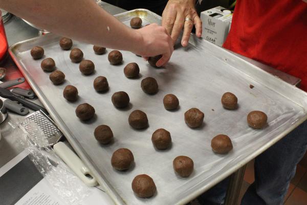 Volunteers make a chocolate variant of the spice cookies from Mike Kelley’s family cookbook March 2 in the Christ the King Family Life Center in Little Rock. (Katie Zakrzewski)