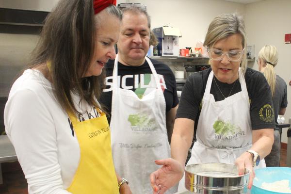 (Left to right) Roz Rector, Mike Kelley and Janie Kelley sift flour as they prepare ingredients for baking March 2 at the Christ the King Family Life Center in Little Rock. (Katie Zakrzewski)