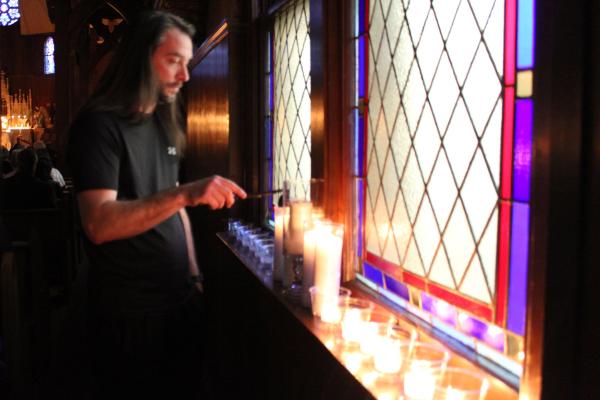 A volunteer extinguishes candles during one of the choral pieces of the Tenebrae Lenten service at Immaculate Heart of Mary Church in North Little Rock (Marche) March 27. (Katie Zakrzewski)