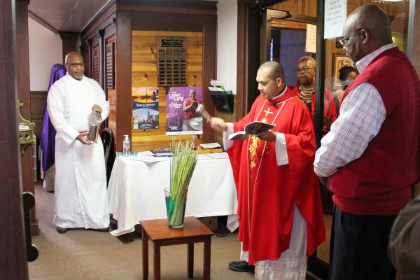 Father Emmanuel Tanu, pastor of St. Bartholomew Church in Little Rock and St. Augustine Church in North Little Rock, blesses palms to be used during Mass at St. Bartholomew Church on Palm Sunday March 24. (Katie Zakrzewski)