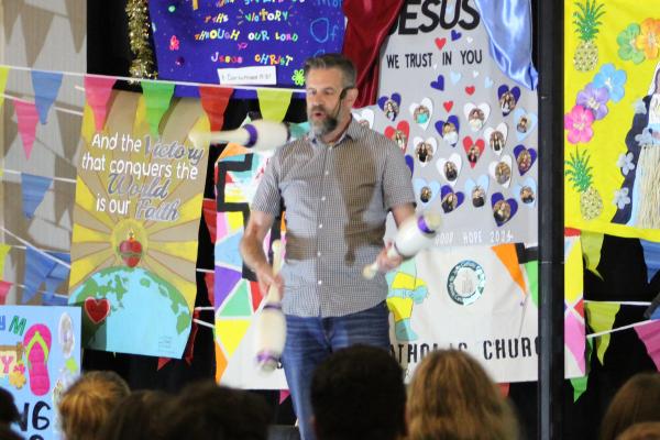 Brad Farmer, co-founder of APeX Ministries, juggles bowling pins during his talk at the statewide youth convention April 5. (Katie Zakrzewski)